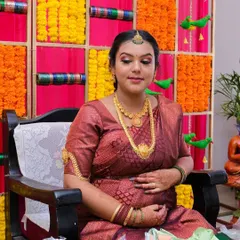 A serene moment from a baby shower celebration. Her makeup is soft and traditional, with defined eyes and a natural base that gives her a beautiful maternal glow.