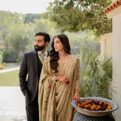 A classic portrait of a couple standing together, looking towards their future. This shot captures a sense of partnership and shared dreams, set against a lush, natural backdrop that adds to the romantic atmosphere.