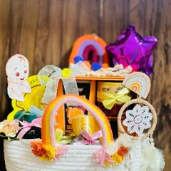 This cheerful hamper for a mom-to-be has a rainbow theme. It's packed in a white woven basket and includes skincare products, a dreamcatcher, and other pampering items to brighten her day.