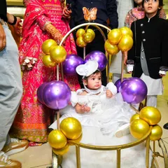 The birthday girl makes a grand entrance in a specially decorated cart adorned with purple and gold balloons, perfectly matching the butterfly theme of the party.