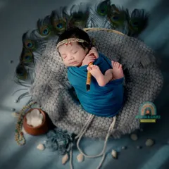 Our little Nandlal, peacefully asleep. This newborn Krishna theme is a beautiful way to celebrate your new arrival, complete with a flute and peacock feathers.