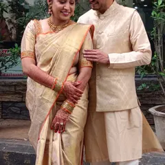 Geeta shines in the elegance of our handwoven Kanchivaram silk saree, sharing a lovely moment with her husband.