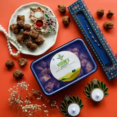 A festive flatlay for Raksha Bandhan, featuring a box of jaggery alongside a rakhi and other traditional items. This setup is designed to connect the product with the emotional core of the festival.