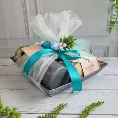 A stylish corporate hamper wrapped in white and turquoise, filled with our handmade treats. It's a memorable gesture for clients and employees.