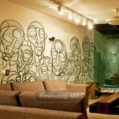 This personality-filled mural features a continuous line-art drawing of abstract faces, creating a unique and highly artistic statement wall in a modern living space.
