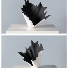 A study in duality, this vase features a dramatic, ruffled black interior emerging from a smooth white exterior. It is a piece that feels both organic and architectural, designed to be viewed from every angle.