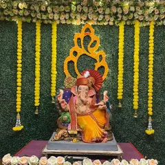 For a fresh and traditional feel, we designed this setup using a lush artificial grass wall. The look is completed with classic yellow marigold garlands and a floral Ganesha emblem, bringing an auspicious and natural vibe to your home.