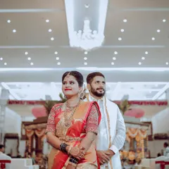 A classic wedding reception look. The couple stands against a beautiful floral wall, ready to greet their guests in a hall that I've decorated to feel grand and welcoming.