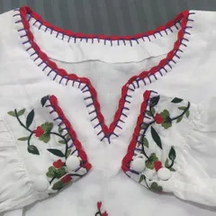 A closer look at the V-neckline, showing how the red crochet lace complements the purple embroidery stitches on the top.