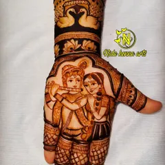 An intricate Radha Krishna figure on the palm, with Krishna playing his flute. This design is framed by swan motifs on the wrist, adding to its elegance.