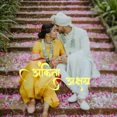 A classic romantic portrait from a Maharashtrian wedding, with the couple seated on steps showered in flower petals. This image highlights the beauty of traditional ceremonies.