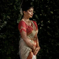 The rich texture of the Kanjivaram silk and the detailed gold embroidery on the blouse are highlighted in this beautiful portrait. This is a timeless look that will be cherished for generations.