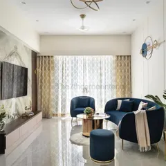 This wide shot of the 'Royal Mansion' living room captures the harmonious balance between the deep blue curved furniture, the book-matched marble TV wall, and the abundant natural light, creating a space of modern luxury.