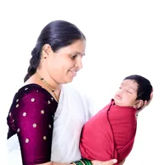 The beginning of a beautiful bond. A grandmother gazes lovingly at her sleeping newborn grandchild, a quiet and tender moment that speaks volumes about family heritage and love.