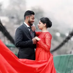 A close-up of the couple on the bridge, sharing a loving look. The red gown adds a vibrant pop of color to this romantic portrait.