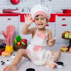 A happy wave from the star of the show! This toddler chef portrait is full of energy and personality.