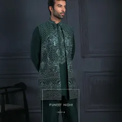 An emerald kurta set paired with a sleeveless embroidered jacket. Subtle geometric patterns and paisley accents flow across the rich green fabric, reflecting understated luxury.