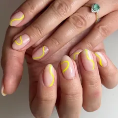 A minimalist abstract design with a single, bright yellow swirl on each nail. This is a great example of how a simple line can make a big impact.