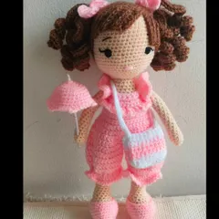 This pretty doll is ready for a rainy day with her little pink umbrella. Her jumpsuit, bag, and even the umbrella are all removable.