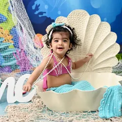 The most adorable little mermaid in the sea. With a sparkling tail and a seashell to sit in, this underwater-themed photoshoot is a whimsical way to celebrate a milestone.