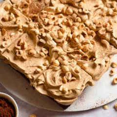 A top-down view of the finished Rum Soaked Dark Chocolate Traybake, generously covered with coffee mousse, toasted hazelnuts, and a dusting of cocoa powder.