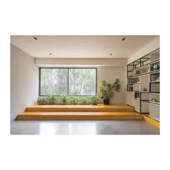 A reading and lounge area in the Meraki Clubhouse, featuring a raised platform with built-in planters. This space offers a quiet retreat with ample natural light and views of the surrounding greenery.