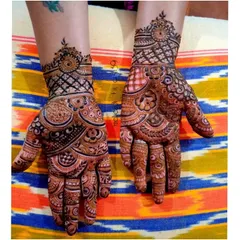 A modern take on festive henna, with geometric patterns on the wrist and a mix of circular motifs on the palm. It's a chic and stylish option.
