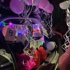 A closer look at another car boot decoration. You can see the birthday cake placed carefully among the balloons and streamers, ready for the celebration.