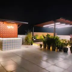 The bar and adjacent pergola at night, forming a complete entertainment zone on this spacious terrace.