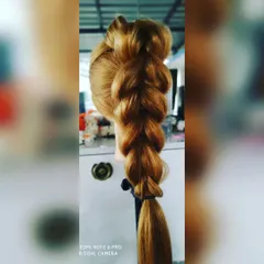 A clear shot of a thick and voluminous pull-through braid. This technique creates the illusion of fuller hair and is a popular choice for sangeet or mehendi functions.