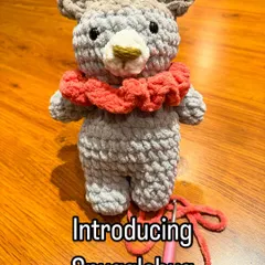 Introducing Snugglebug the bear! With his cozy red collar, he's the perfect friend for your little one to cuddle with. This amigurumi bear is handmade and designed to be a cherished companion.