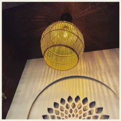 This woven rattan pendant light casts beautiful, intricate shadows on the wall and ceiling. Paired with a decorative CNC-cut wall panel, it creates a focal point that is both earthy and elegant.