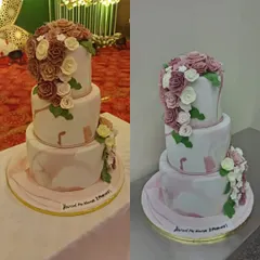 A magnificent three-tiered wedding cake with a marble effect and cascading sugar flowers in shades of mauve and white. This cake is a true statement piece for a grand reception.