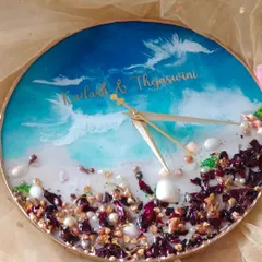 This beach-themed clock combines preserved flowers with the calming aesthetic of the ocean. The lower half is filled with preserved petals and shells, while the top half features a beautiful blue wave design.