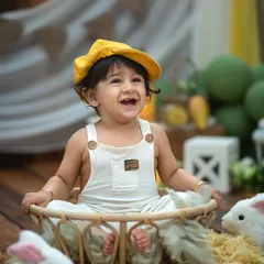 A happy little farmer in our mango-themed setup. The bright yellow hat and huge smile perfectly capture the fun and flavor of this unique session.