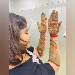 The happy client showing off her unique henna design. You can see the pet portrait on one arm and the intricate patterns on the other, a perfect blend of personal and traditional.
