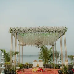A stunning lakeside mandap with a canopy of white florals and hanging crystals. We specialize in creating dreamlike settings that make the most of beautiful natural surroundings.