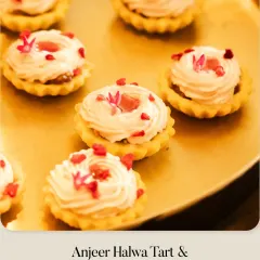 A variation of the Anjeer Halwa Tart, this version is topped with a delicate Raspberry Cream and garnished with edible flower petals, served on a golden platter.
