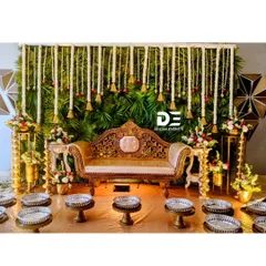 For this traditional Seemantham, I created a lush backdrop of green leaves adorned with hanging jasmine garlands and temple bells. The ornate golden sofa provides a regal seat for the mother-to-be.