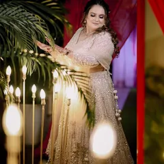 A beautiful portrait of the bride, Pooja, during her engagement ceremony, surrounded by warm, decorative lights.