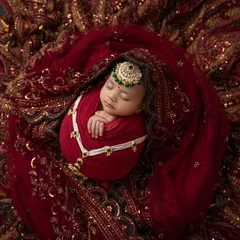 Another beautiful angle of the desi heritage theme, capturing the baby's peaceful sleep amidst the splendor of her family's traditions.