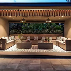 A view of the main seating area on the Chhabria's Terrace. The large U-shaped sofa is set against a backdrop of vertical gardens, creating a cozy and intimate gathering space with a strong connection to nature.