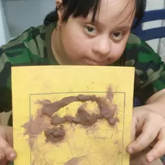 This is one of my favorite moments. A young participant with special needs proudly holds up her clay silhouette, a piece that is uniquely hers. The joy and confidence in her expression capture the true purpose of my work: creating a safe, celebratory space for self expression.