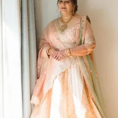 An ethereal and soft makeup look for a family member, captured in beautiful natural light. The pastel tones of her lehenga are matched with subtle makeup and an elegant updo for a graceful appearance.