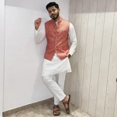 A different pose in the same coral floral Nehru jacket and white kurta set, showing a relaxed and stylish look perfect for a festive occasion.