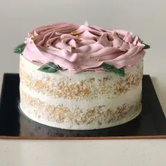 A simple yet elegant vanilla and strawberry cake. This is a semi naked Genoise sponge with layers of light vanilla buttercream and a fresh strawberry filling, decorated with a buttercream rose on top.