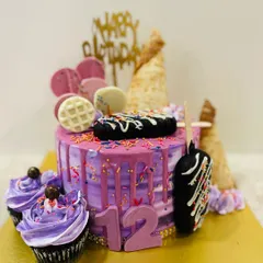 A fun and trendy ice cream themed drip cake for a 12th birthday. This purple cake is loaded with cakesicles, waffle cones, and matching cupcakes.