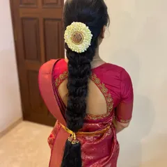 A clean and elegant South Indian braid, perfect for any ceremony. The look is completed with a jasmine floral arrangement and a traditional kunjalam (tassel) at the end of the plait.