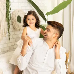 A sweet, candid moment between a father and his daughter. Her perch on his shoulders and their shared smiles make for a natural and heartwarming portrait.