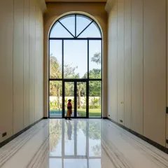 Inside the Sultanpur farmhouse, this double-height archway is a perfect example of neo-classical elegance meeting modern simplicity. The grand scale, combined with Equator White marble floors, creates a light-filled, inviting space that connects seamlessly with the outdoors.